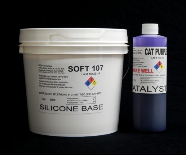 A white container labeled "10 lb Kit : Soft 107" next to a purple bottle labeled "cat purple catalyst," both against a black background.