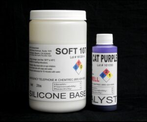 Two containers labeled "2 lb Kit : Soft 107 – (7 shore A durometer) – Regular Pot Life Mold Making Silicone" and "cat purple catalyst" for industrial use, displayed against a black background.