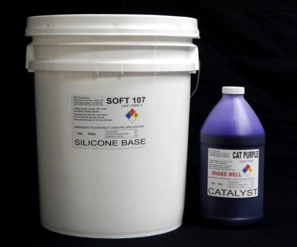 A large white bucket labeled "44 lb Kit : Soft 107" next to a smaller purple bottle with "cat purple catalyst" label, both against a black background.