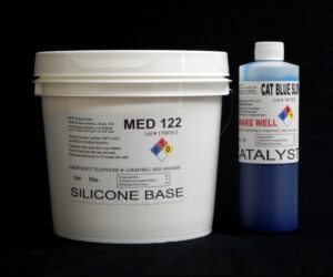 White plastic bucket labeled '10 lb Kit : Medium 122 – (22 shore A durometer) – Longer Pot Life Mold Making Silicone' and a blue plastic bottle labeled 'catalyst' arranged on a black background.