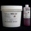 A large white bucket labeled "10 lb Kit : Medium 122 – (22 shore A durometer) – Fast Curing Mold Making Silicone" alongside a smaller bottle labeled "catalyst." both items have hazard symbols and black text on a black background.