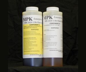 Two bottles labeled as 2 lb Kit MPK-1019 epoxy resin components a and b, each with extensive warning and product information, against a black background.