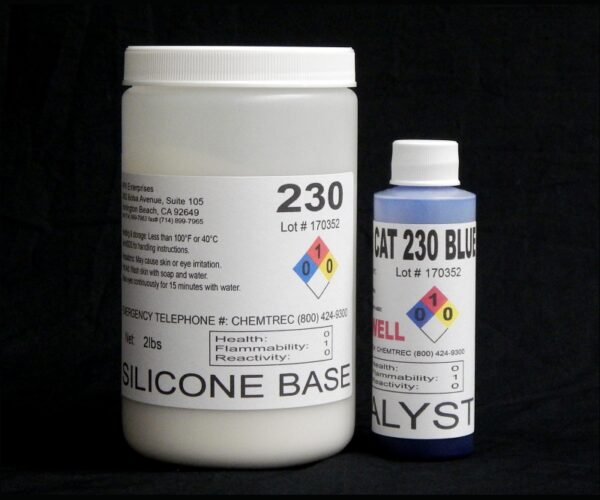 Two containers labeled "2 lb Kit : QM 230 FG B: 30 shore A – Platinum Silicone" and "Blue Catalyst," respectively, displaying hazard ratings, set against a black background.