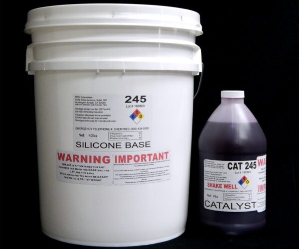 A white plastic bucket labeled "44 lb Kit : QM 245 : 45 shore A – Platinum Silicone" and a dark bottle labeled "catalyst" against a black background.