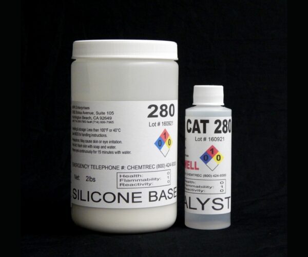 Two containers of 2 lb Kit : QM 280 : 80 shore A – Platinum Silicone base and catalyst against a black background, featuring labels with hazard symbols and storage instructions.