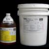 A large white plastic 5 Gallon Pail Kit MPK 400-81A-100sec BLACK next to a brown bottle labeled "black 4006-1a-lv-100s" on a black background.