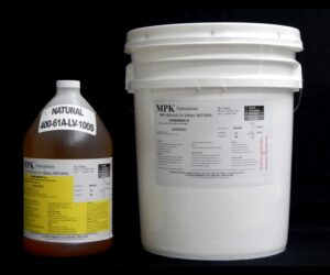 Two industrial containers on a black background, one a labeled jug of 5 Gallon Kit MPK 400-61A-100sec NATURAL degreaser, the other a white plastic bucket with a label.