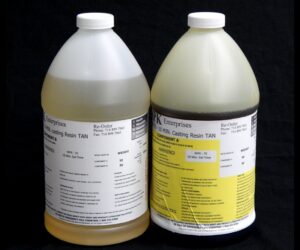 Two large containers of 8 lb Kit : MPK-70 : 10 Min Polyurethane Casting Resin, labeled with chemical information and contact details, against a black background.