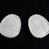 A pair of white pads sitting on top of a black surface.