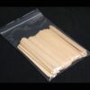 A bag of wooden popsicle sticks on top of a table.