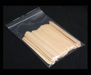 A bag of wooden popsicle sticks on top of a table.