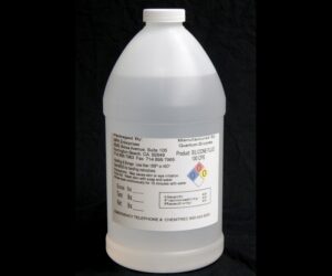 A large white plastic jug with a chemical label, featuring hazard symbols, on a black background containing 4 lb/64 oz Kit Silicone Fluid.