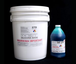 White plastic bucket labeled "44 lb Kit : QM 270 : 70 shore A – Platinum Silicone" and a blue bottle labeled "catalyst" on a black background.